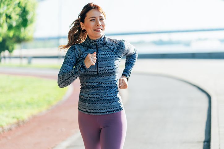 A woman running outdoors along a bridge